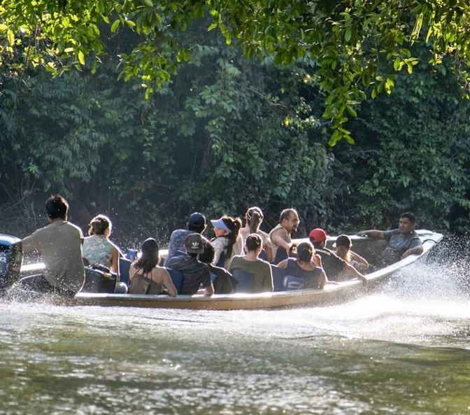 Travelers arriving by canoe at Cuyabeno Dolphin Lodge