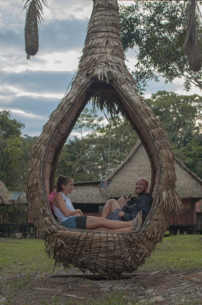 Guests relaxing in the hanging nest chair at Cuyabeno Dolphin Lodge