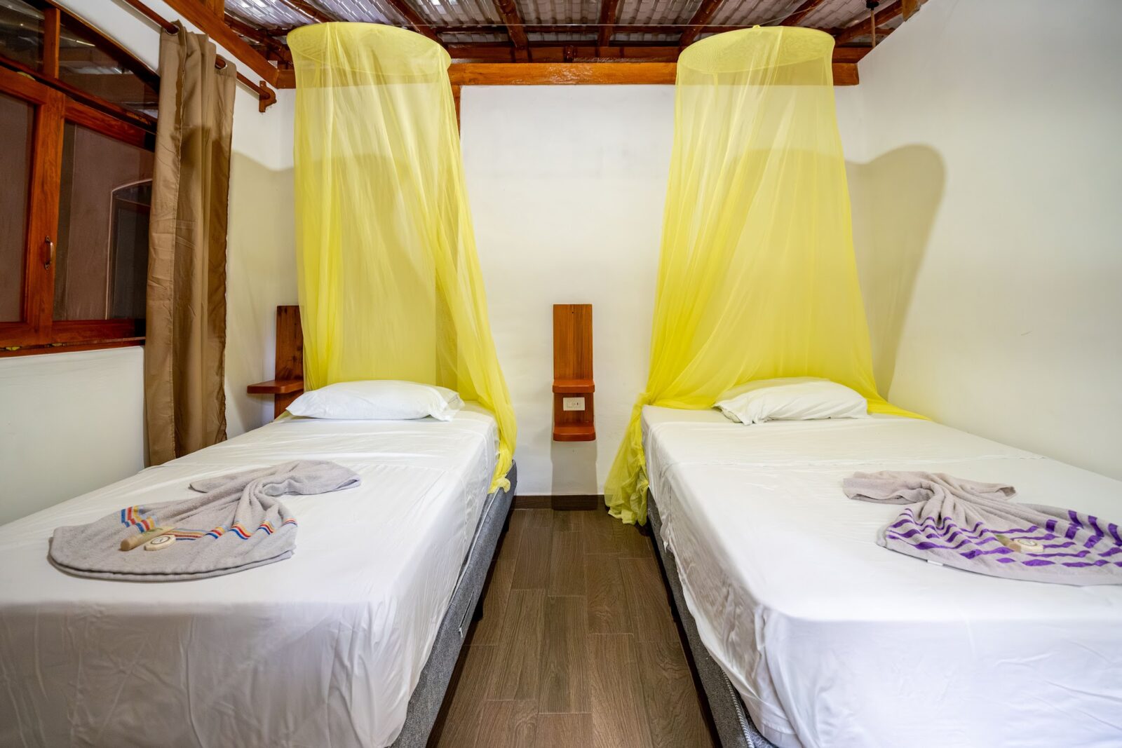Twin room with yellow canopy nets at Cuyabeno Dolphin Lodge